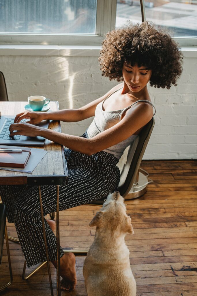 A person looking at their dog while working their expat job