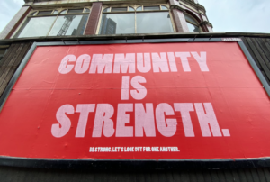 a red billboard with a text saying "community is strength", reflecting the value of MSP peer groups