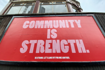 a red billboard with a text saying "community is strength", reflecting the value of MSP peer groups